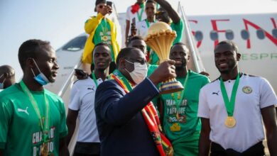 Macky SALL et les joueurs tenant la coupe d'afrique